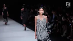 Seorang model berjalan diatas catwalk membawakan rancangan karya Lulu Lutfi Labibi dalam Jakarta Fashion Week 2018 di Senayan City, Jakarta, Kamis (26/10). Pada JFW 2018 Lulu menghadirkan koleksi bertema 'Persimpangan'. (Liputan6.com/Faizal Fanani)