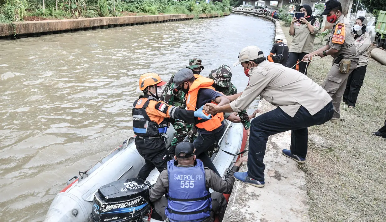 Petugas gabungan mengevakuasi korban dengan perahu karet saat simulasi penanganan banjir di Kalimalang, Cipinang Melayu, Rabu (17/11/2021). Simulasi digelar dalam rangka kesiapsiagaan petugas dalam penanganan korban banjir, terutama evakuasi warga yang terpapar Covid-19 (merdeka.com/Iqbal S Nugroho)