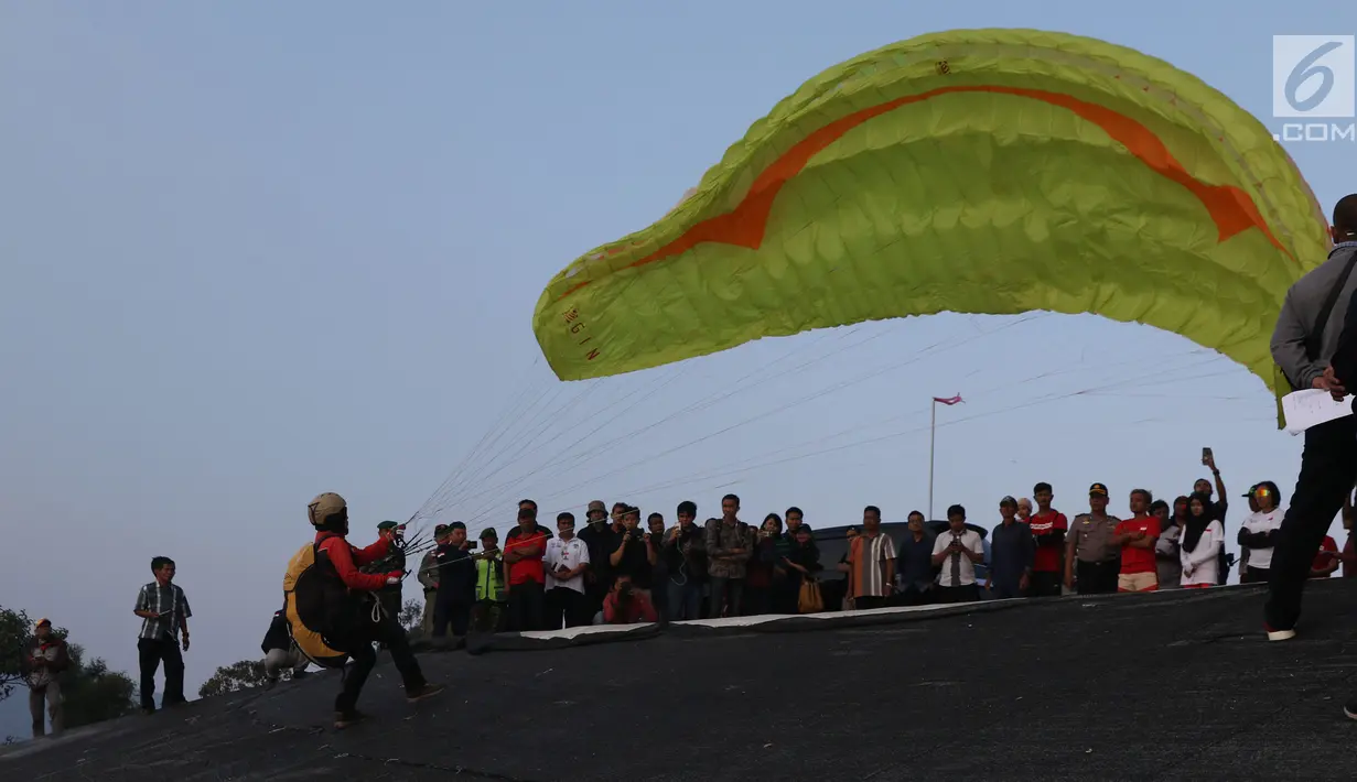 Atlet Paralayang Indonesia bersiap melakukan start saat latihan terbang nomor Sport Landing di kawasan Puncak, Cianjur, Jawa Barat, Kamis (26/7). Latihan ini mematangkan persiapan jelang laga Asian Games 2018. (Liputan6.com/Helmi Fithriansyah)