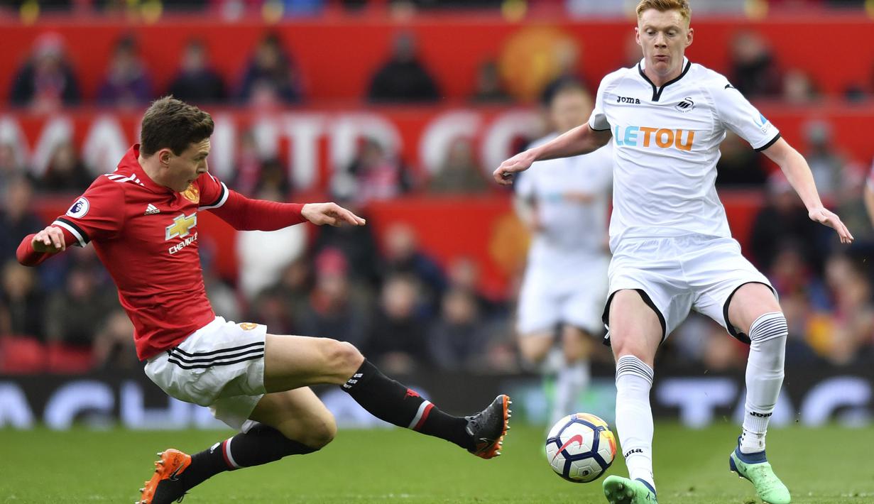 Aksi pemain Manchester United, Victor Lindelof (kiri) menghalau bola dari kejaran pemain Swansea City, Sam Clucas pada laga Premier League di Old Trafford, (31/3/2018).  Manchester United menang 2-0. (Anthony Devlin/PA via AP)