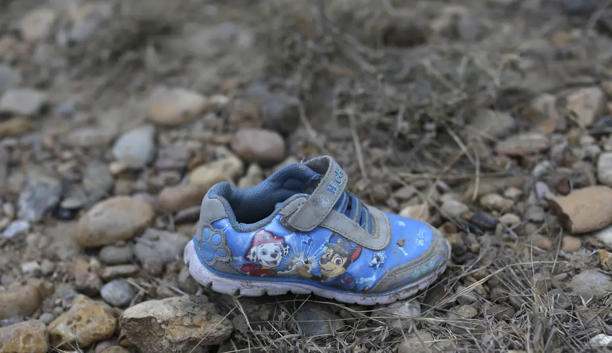 Sepatu anak-anak tergeletak di tanah dekat tepi sungai Rio Grande di Roma, Texas, 28 Maret 2021. Roma, kota berpenduduk 10.000 orang di Lembah Rio Grande Texas itu adalah pusat penyeberangan ilegal terbaru, tempat banyak keluarga dan anak-anak memasuki AS untuk mencari suaka. (AP/Dario Lopez-Mills)