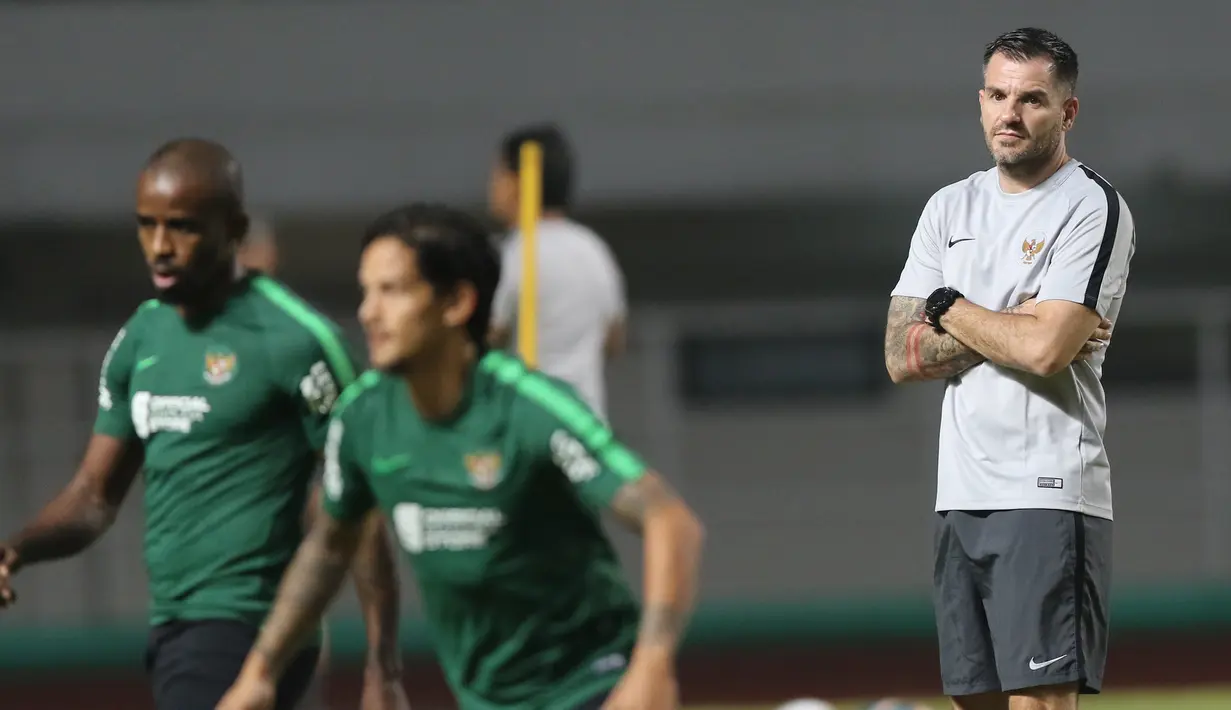 Pelatih Timnas Indonesia, Simon McMenemy, mengamati anak asuhnya saat sesi latihan di Stadion Pakansari, Bogor, Kamis (22/8). Latihan tersebut untuk persiapan jelang laga kualifikasi Piala Dunia 2022. (Bola.com/M Iqbal Ichsan)
