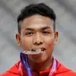 Sprinter Indonesia, Lalu Muhammad Zohri menggigit medali usai mengikuti kategori 100 meter dalam Kejuaraan Atletik Asia di Doha, Qatar, Senin (22/4). Zohri merebut medali perak dengan catatan waktu 10,13 detik yang juga memecahkan rekor pelari tercepat Asia Tenggara, Suryo Agung. (AP/Vincent Thian)