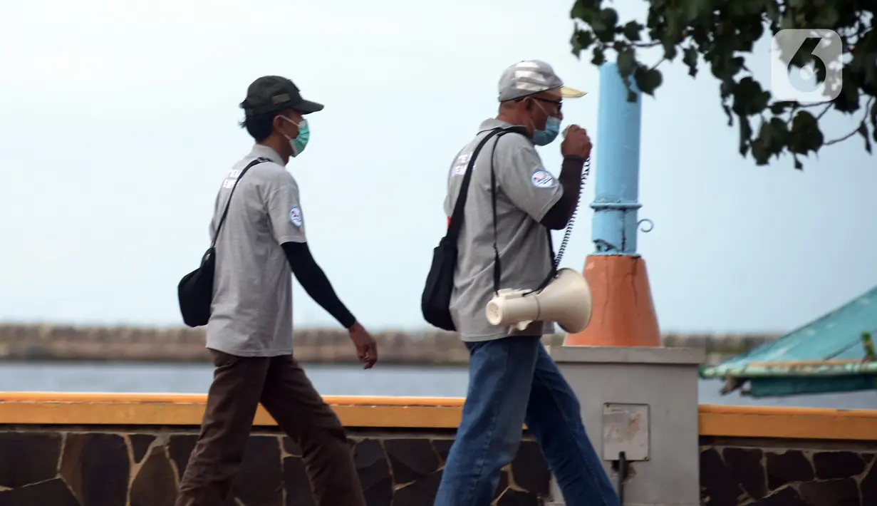 Petugas mengimbau pengunjung saat libur Tahun Baru di Pantai Ancol, Jakarta, Sabtu (1/1/2022). Memasuki libur akhir pekan awal Tahun Baru 2022, kawasan Taman Impian Jaya Ancol hanya buka dari jam 06.00-14.00 WIB, hal ini untuk mencegah penyebaran COVID-19 varian Omicron. (merdeka.com/Imam Buhori)