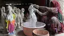 Seorang wanita memberikan warna dasar istri dewa Hindu Rama, dewi Sita di sebuah lokakarya di Hyderabad, India (15/3). Festival Rama Navami tersebut untuk merayakan kelahiran dewa Rama di seluruh India. (AFP/Noah Seelam)