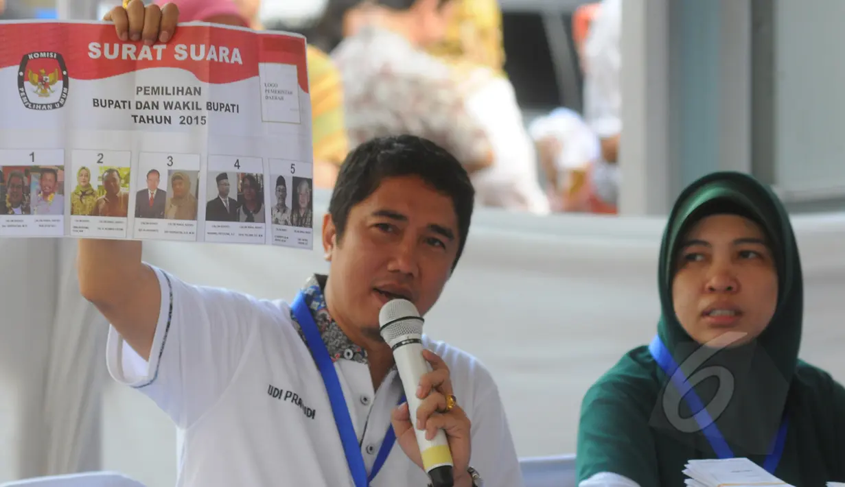 Seorang petugas menunjukan surat suara saat simulasi pemungutan dan penghitungan suara Pemilihan Gubernur, Bupati, serta Walikota di TPS Halaman Gedung KPU RI, Jakarta Pusat, Selasa (7/4/2015). (Liputan6.com/Herman Zakharia)