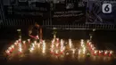 Seorang pencari suaka menyalakan lilin membentuk nama kota di Afghanistan saat aksi keprihatinan yang digelar di depan kantor UNHCR, Jakarta, Selasa (11/5/2021). Mereka prihatin atas peristiwa serangan bom yang menewaskan puluhan siswi di Kabul, Afghanistan. (Liputan6.com/Helmi Fithriansyah)