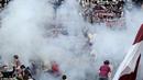 Penggemar Torino yang ditelan oleh asap setelah flare dilemparkan ke kerumunan selama derby Turin. (Dailymail)