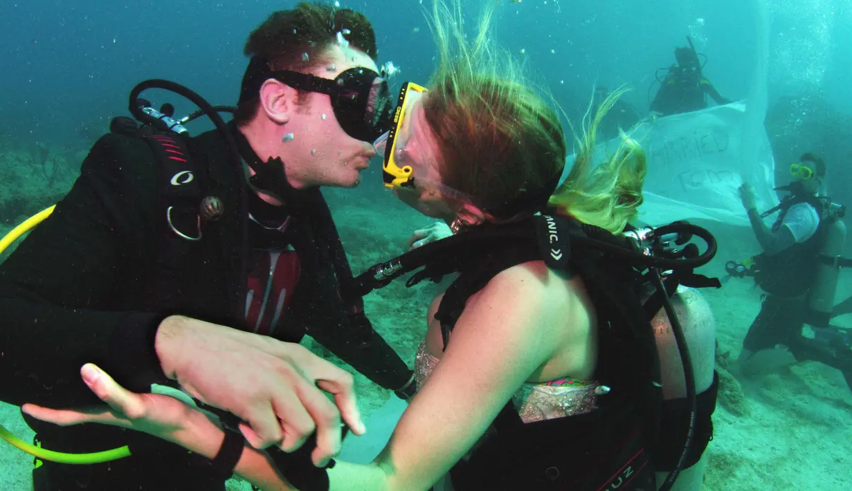 Sersan Thomas Mould dan Sandra Hyde berciuman usai melangsungkan pernikahan di Florida Keys National Marine Sanctuary (21/12). Setelah pacaran empat tahun pasangan ini memutuskan menikah di bawah laut. (Frazier Nivens/Florida Keys News Bureau via AP)
