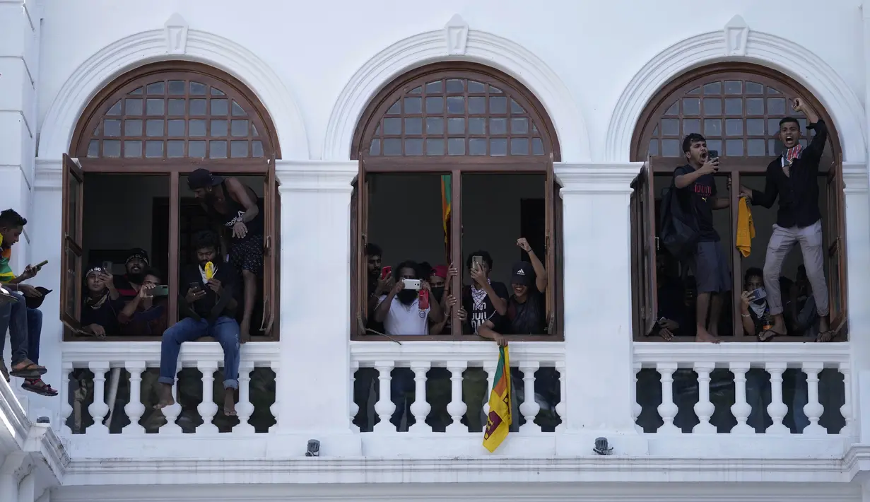 Para pengunjuk rasa meneriakkan slogan-slogan setelah menyerbu kantor Perdana Menteri Sri Lanka Ranil Wickremesinghe, menuntut dia mengundurkan diri setelah presiden Gotabaya Rajapaksa melarikan diri dari negara itu di tengah krisis ekonomi di Kolombo, Sri Lanka, Rabu (13/7/2022). (AP Photo/Eranga Jayawardena)