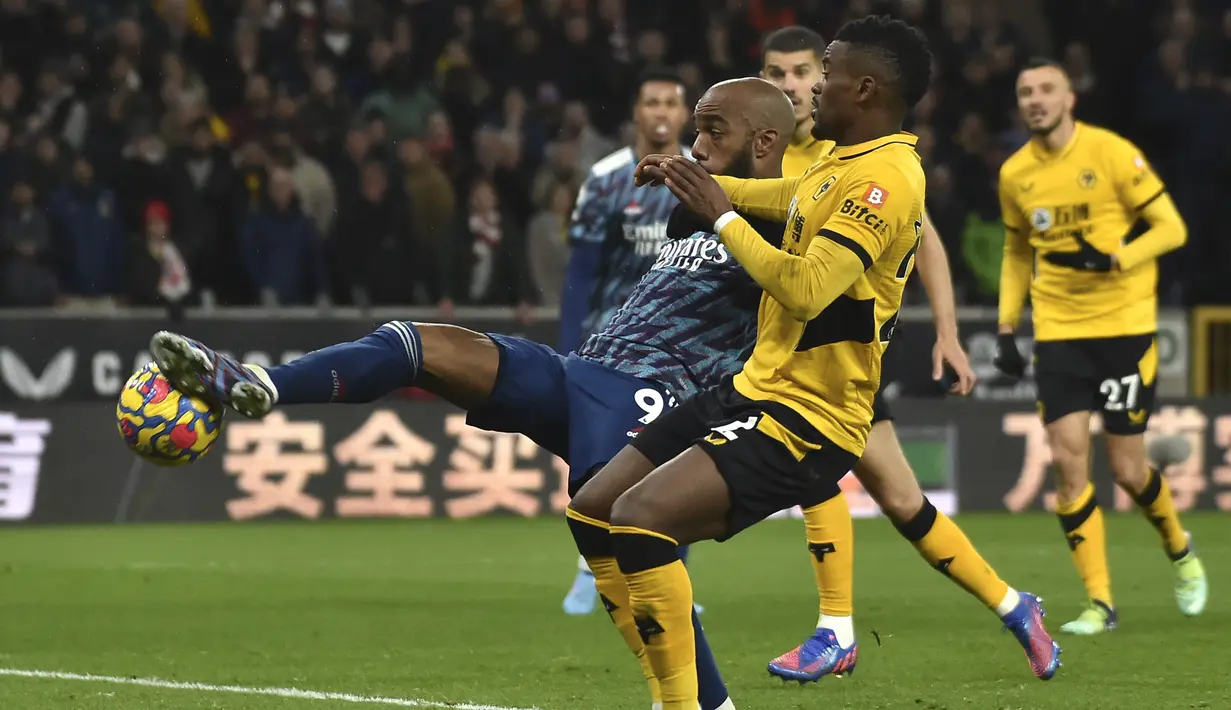 Penyerang Arsenal, Alexandre Lacazette (kiri) berebut bola dengan pemain Wolverhampton Wanderers, Nelson Semedo selama pertandingan lanjutan Liga Inggris di stadion Molineux di Wolverhampton, Inggris, Jumat (11/2/2022). Arsenal menang tipis atas Wolverhampton Wande 1-0. (AP Photo/Rui Vieira)