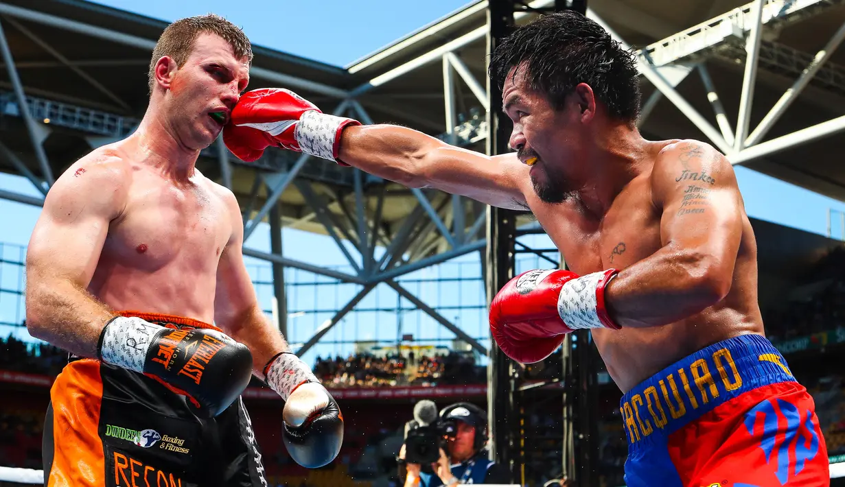 Petinju Filipina, Manny Pacquiao, mendaratkan pukulan ke Jeff Horn (Australia) pada perebutan sabuk juara kelas welter versi WBO di Stadion Suncorp, Brisbane, Minggu (2/7). Horn mengalahkan Pacquiao dalam pertarungan 12 ronde. (PATRICK HAMILTON/AFP) 