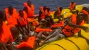 Sejumlah imigran menunggu di atas perahu karet untuk diselamatkan di lepas pantai Libya, Selasa (25/7). Kapal penyelamat kemanusiaan milik LSM asal Spanyol, Proactiva Open Arms, menemukan 13 jasad di atas perahu karet tersebut. (AP/Santi Palacios)