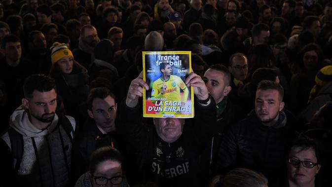 Ekspresi pendukung FC Nantes yang larut dalam kedukaan. Hal tersebut terjadi setelah mendengar kabar mantan bintang mereka, Emiliano Sala tewas karena pesawat yang ditumpanginya hilang dari kontak. (AFP/Loic Venance)