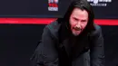 Aktor Keanu Reeves mengabadikan cetak tangan di atas semen di halaman depan TCL Chinese Theatre, Los Angeles, Selasa (14/5/2019). Aktor 54 tahun itu mendapat penghargaan membuat cetakan tangan dan kaki untuk merayakan keberhasilan karirnya dalam film. (REUTERS/Mario Anzuoni)