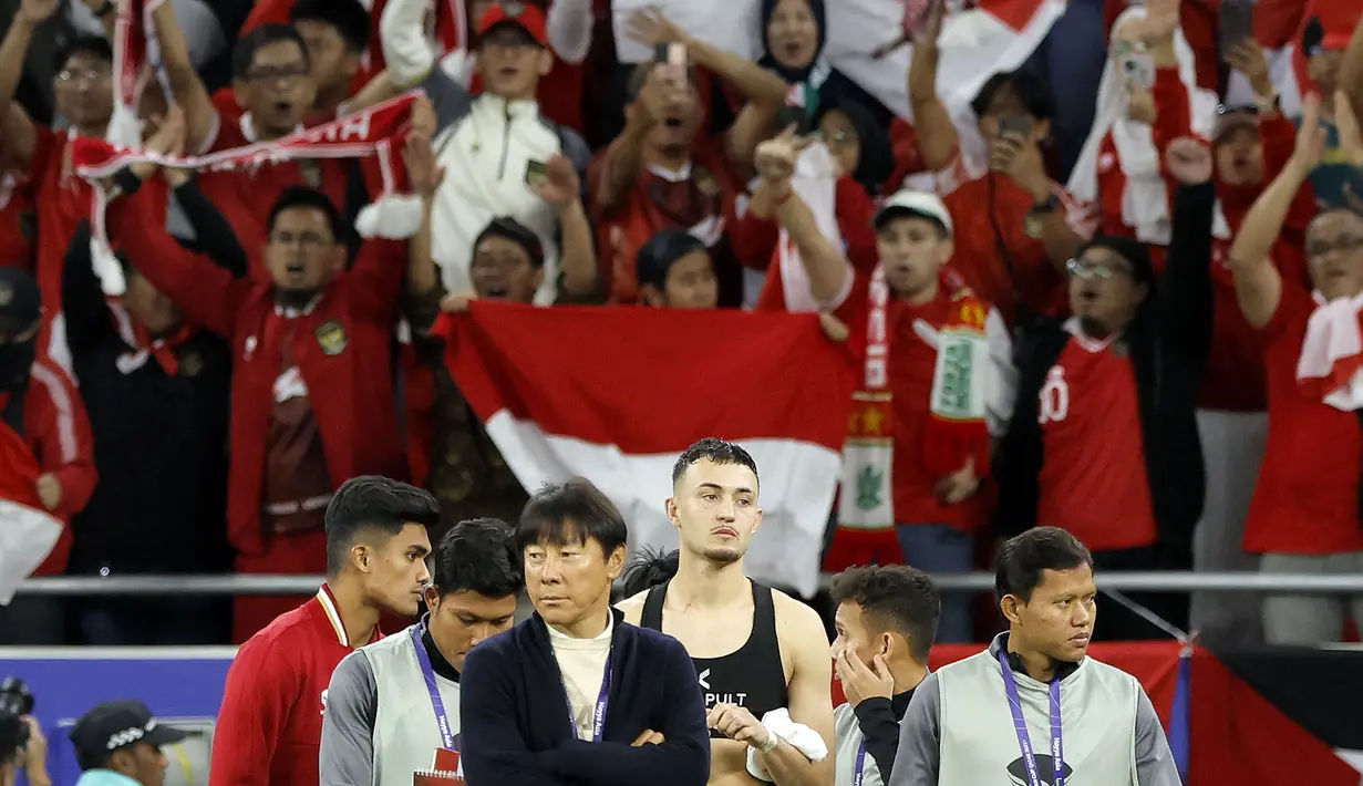 Pelatih Timnas Indonesia, Shin Tae-yong (tengah) bersama para pemainnya berjalan meninggalkan lapangan setelah menderita kekalahan 1-3 dari Timnas Irak pada laga pertama Grup D Piala Asia 2023 Qatar di Ahmad bin Ali Stadium, Al-Rayyan, Doha, Senin (15/1/2024). (AFP/Karim Jaafar)