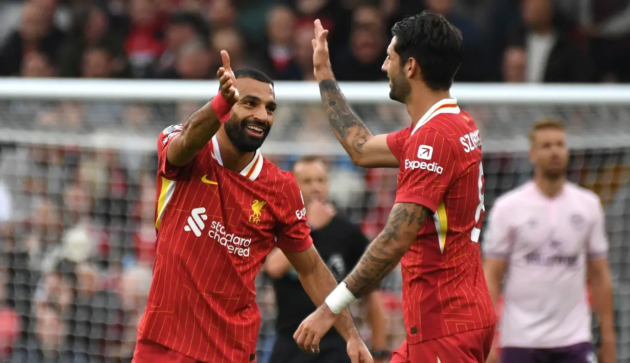 Pemain Liverpool, Mohamed Salah (kiri) melakukan selebrasi dengan Dominik Szoboszlai setelah mencetak gol kedua timnya selama pertandingan Liga Premier Inggris melawan Brentford di Stadion Anfield, Liverpool, Minggu, 25 Agustus 2024. (AP Photo/Rui Vieira)