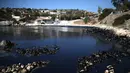 Sebuah pantai berubah menjadi hitam akibat tumpahan minyak di Pulau Salamina, Yunani, Selasa (12/9). Tumpahan minyak tersebut berasal dari kapal tanker Agia Zoni II yang tenggelam Minggu lalu saat akan berlabuh di pantai Salamina. (AP/Petros Giannakouris)