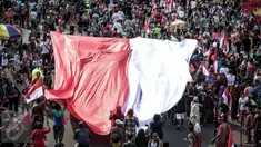 Peserta membentangkan bendera merah putih raksasa pada Karnaval Cinta Budaya NKRI di MH Thamrin, Jakarta, Minggu (20/11). Ribuan peserta yang terdiri dari berbagai elemen membawa dan mengibarkan bendera merah putih. (Liputan6.com/Faizal Fanani)