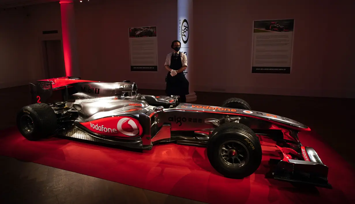 Seorang staf berdiri di samping mobil McLaren MP4-25A Mercedes yang dikendarai Lewis Hamilton pada GP Turki 2010, di Sotheby London, Selasa (18/5/2021). Mobil McLaren tersebut  akan dilelang di Grand Prix (GP) Inggris pada bulan Juli 2021 mendatang. (AP Photo/Alberto Pezzali)