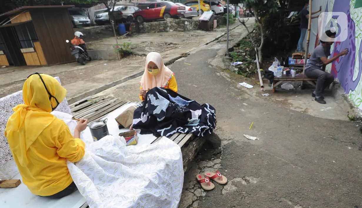 Warga menyelesaikan pembuatan batik tulis saat pelaksanaan kegiatan mural Raincity Strike #8 di Kampung Batik Cibuluh, Bogor, Minggu (22/11/2020). Kegiatan seni mural ini melibatkan puluhan seniman mural se-Jabodetabek di kampung batik. (merdeka.com/Arie Basuki)