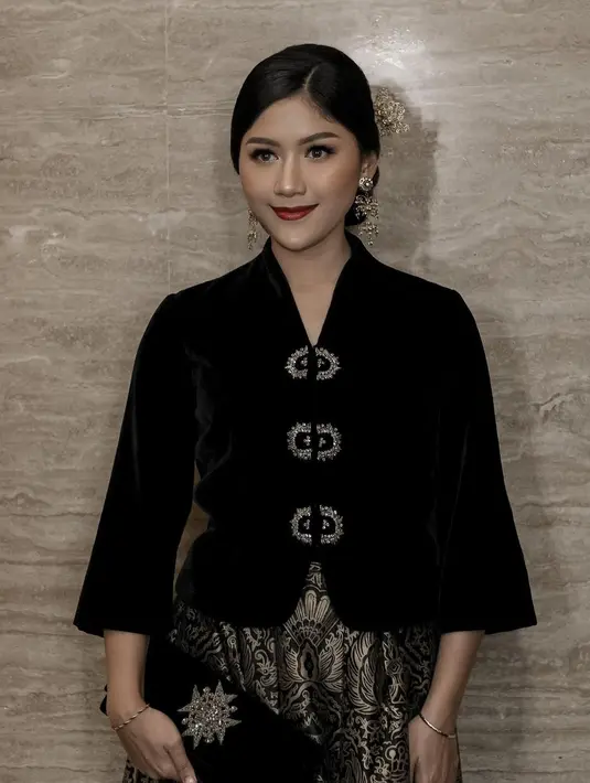 Bisa jadi inspirasi tampilan kondangan yang elegan, Erina tampil mengenakan kebaya pendek modern hitam yang memiliki kancing keemasan. Dipadukan rok batik bernuansa hitam emas yang menawan. [@erinagudono]
