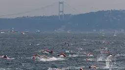 Ratusan atlet renang mengikuti lomba renang dari Asia hingga Eropa di Selat Bosphorus ke-30, Istanbul, Turki, (22/7). Lebih dari 2.000 peserta terjun dari feri dan berenang sejauh sekitar 6,5 km di acara tersebut. (AP Photo/Lefteris Pitarakis)