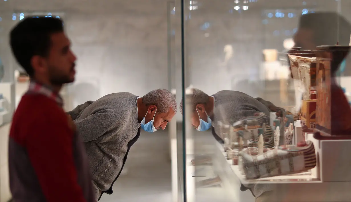 Pengunjung melihat artefak yang dipamerkan di Museum Nasional Peradaban Mesir (NMEC), Distrik Fustat, Kairo Lama, Mesir, 4 April 2021. Museum Nasional Peradaban Mesir kembali dibuka sehari setelah upacara Parade Emas Firaun. (Mahmoud KHALED/AFP)