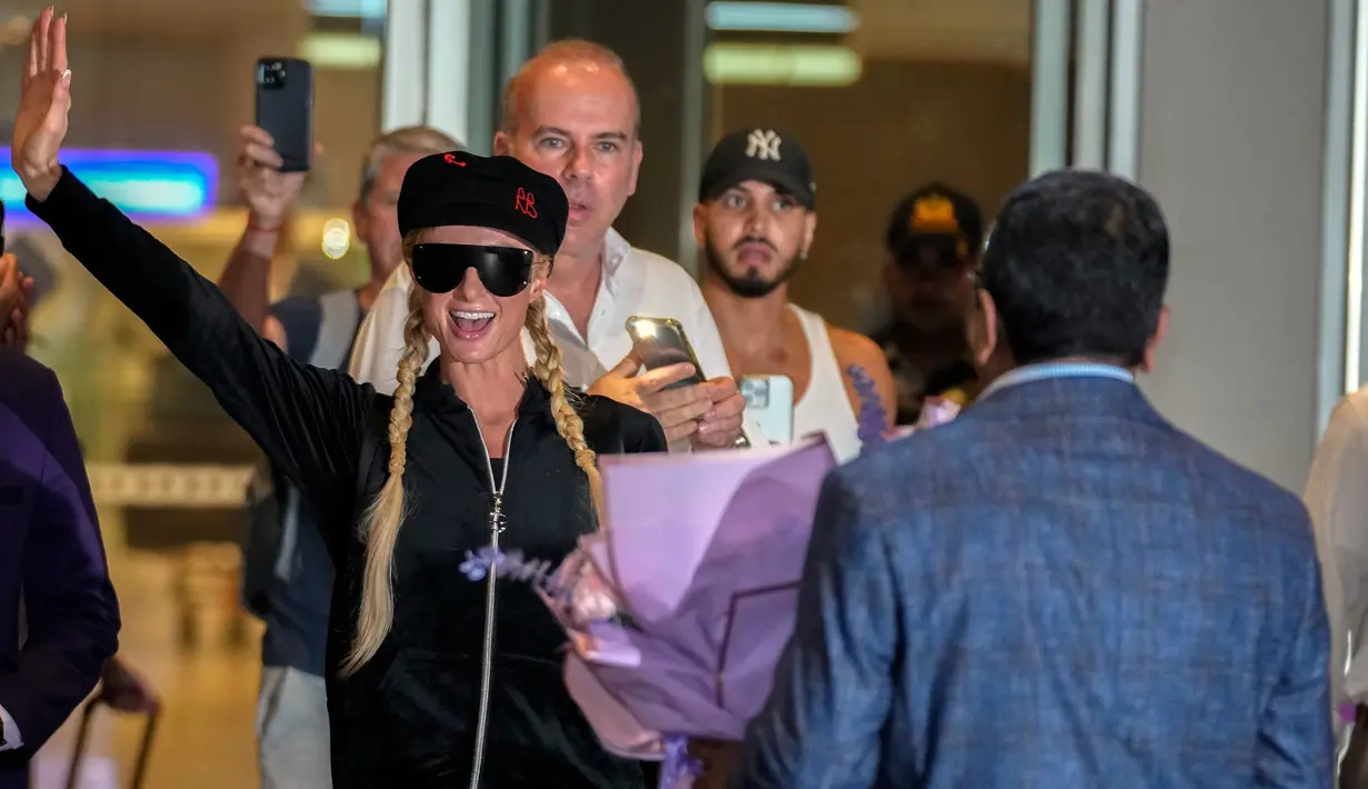 Selebritas Amerika Serikat Paris Hilton melambai kepada fotografer saat tiba di Bandara Internasional Chhatrapati Shivaji, Mumbai, India, 19 Oktober 2022. Setibanya di bandara, Paris langsung disambut oleh lautan penggemar yang memberinya buket bunga. (AP Photo/Rafiq Maqbool)