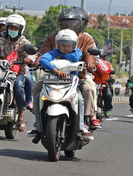 <p>Pemudik sepeda motor melintas di Jalur Pantura, Jawa Barat, Minggu (2/6/2019). Sejumlah pemudik sepeda motor terpantau mengabaikan keselamatan dengan membawa barang bawaan dan penumpang melebihi kapasitas. (Liputan6.com/Herman Zakharia)</p>