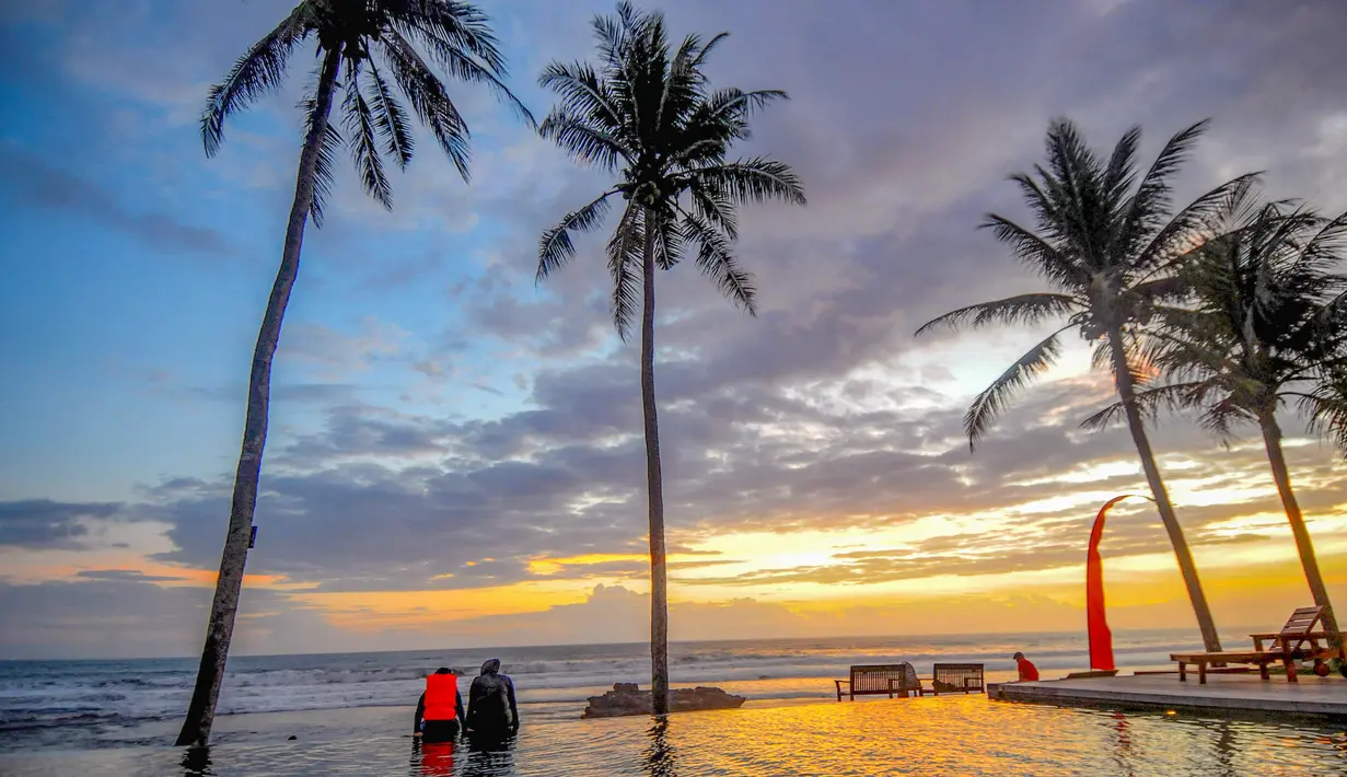 Daya tarik pantai ini terletak pada hamparan pasir hitamnya yang lembut dan ombak yang cenderung landai, sehingga cocok untuk berbagai aktivitas seperti berjemur, olahraga pantai, bermain, hingga berenang. Tampak dalam foto, pengunjung beraktifitas menikmati waktu senja Pantai pasut di Tabanan, Bali. (merdeka.com/Arie Basuki)