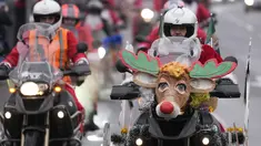Pengendara sepeda motor yang mengenakan kostum Sinterklas mengendarai motor mereka selama parade Sinterklas di Beograd, Serbia, Minggu (26/12/2021). Mereka melakukan konvoi menuju rumah sakit anak-anak untuk membagikan mainan hadiah Natal kepada pasien di sana. (AP Photo/Darko Vojinovic)