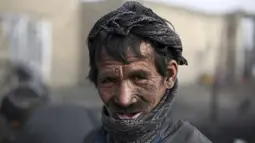 Seorang buruh Afghanistan berpose ketika ia bekerja di pasar arang di pinggiran Kabul, Afghanistan (18/12/2019). Di musim dingin, harga kayu dan arang naik di antara semua kebutuhan lain untuk warga Afghanistan. (AP Photo / Rahmat Gul)