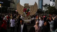 Warga membawa lambang Garuda Pancasila saat Kirab Pancasila pada Hari Bebas Kendaraan Bermotor (HBKB) di kawasan Bundaran HI, Jakarta, Minggu (28/5/2023). (Liputan6.com/Johan Tallo)