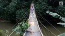 Jembatan yang berada di atas Sungai Ciliwung ini menjadi salah satu akses bagi warga untuk mempersingkat waktu menyeberang Lenteng Agung, Jakarta, Rabu (24/5). (Liputan6.com/Immanuel Antonius)