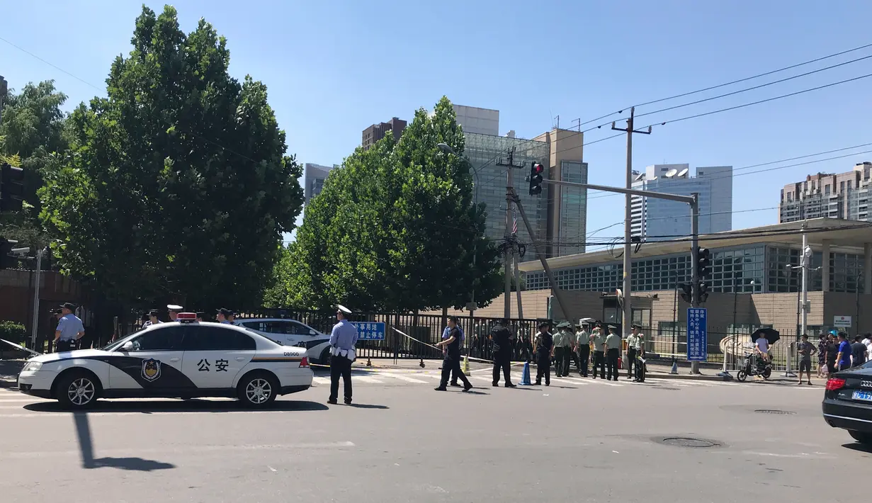 Petugas berseragam militer dan personel keamanan China berada di lokasi ledakan di luar kedutaan besar Amerika Serikat di Beijing, Kamis (26/7). Ledakan itu terjadi di sebuah distrik tempat beberapa  kedutaan besar berkantor. (AP/Mark Schiefelbein)