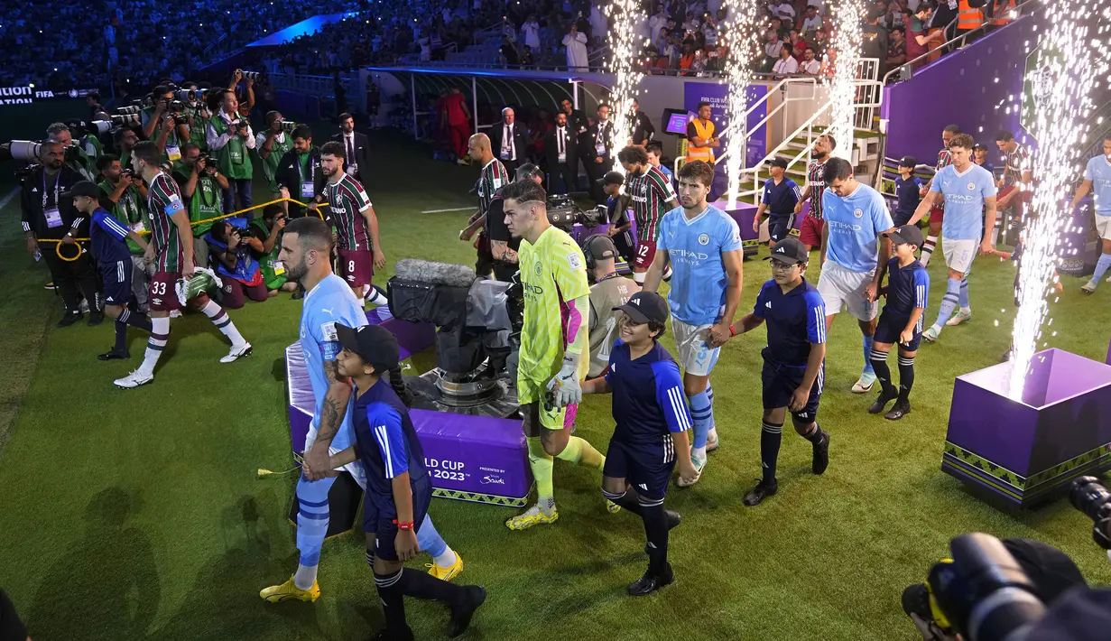Sejumlah pemain Manchester City dan Fluminense berjalan memasuki lapangan saat laga final Piala Dunia Antarklub 2023 di King Abdullah Sports City, Jeddah, Arab Saudi, Sabtu (23/12/2023) dini hari WIB. (AP Photo/Manu Fernandez)