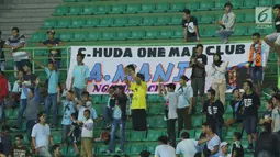 Suporter Laskar Joko Tingkir membentangkan spanduk bertuliskan nama alm Choirul Huda saat menyaksikan laga Persela melawan Bhayangkara FC di Stadion Patriot Candrabhaga, Bekasi, Jumat (27/10). (Liputan6.com/Helmi Fithriansyah)