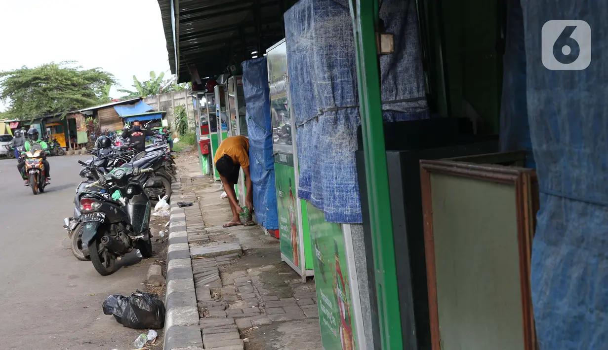 Salah satu pedagang menutup lapaknya di kawasan Kuningan, Jakarta, Kamis (2/4/2020). Minimnya aktivitas perkantoran di Jakarta akibat pandemi COVID-19 membuat sejumlah pedagang warung kaki lima memilih untuk menutup dagangannya karena sepi pembeli. (Liputan6.com/Helmi Fithriansyah)