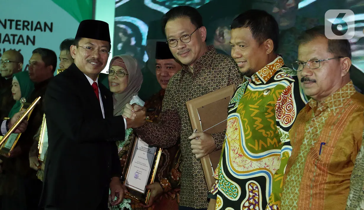 Menteri Kesehatan Terawan Agus Putranto (kiri) memberikan penghargaan kepada Komisaris Utama Emtek Grup Eddy Sariaatmadja dalam acara Anugerah Menteri Kesehatan 2019 di Jakarta, Selasa (12/11/2019). Eddy Sariaatmadja dinilai berjasa dalam pembangunan bidang kesehatan. (Liputan6.com/Johan Tallo)