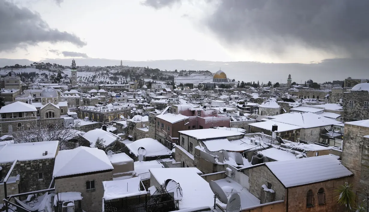 Salju menutupi Masjid Kubah Batu di kompleks Masjid Al Aqsa di Kota Tua Yerusalem, Kamis (27/1/2022). Hujan salju yang jarang melanda sebagian wilayah Israel dan Tepi Barat, menutup sekolah dan bisnis. (AP Photo/Mahmoud Illean)
