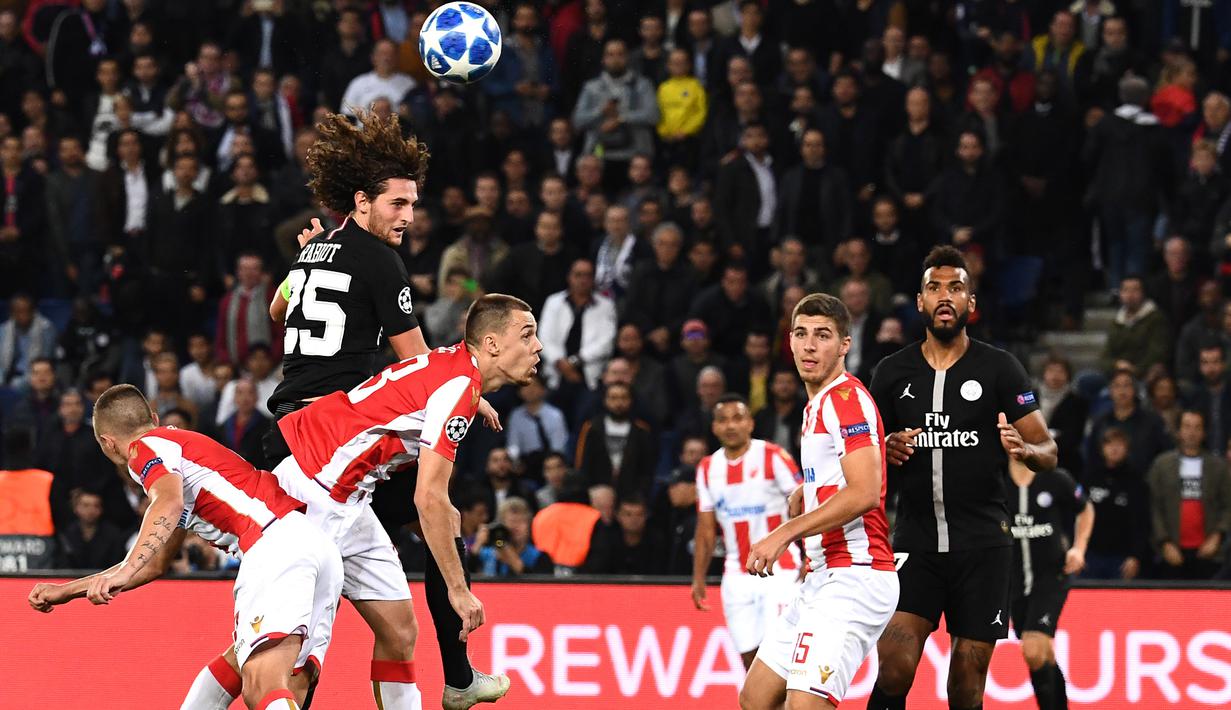 Gelandang PSG, Adrien Rabiot, duel udara dengan bek Red Star, Milan Rodic, pada laga Liga Champions di Stadion Parc des Princes, Paris, Rabu (3/10/2018). PSG menang 6-1 atas Red Star. (AFP/Anne-Christine Poujoulat)