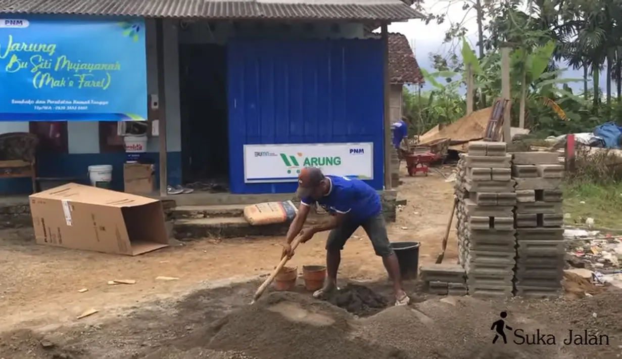 Tampak seorang pekerja bangunan didepan rumah Farel sedang mengaduk semen. (Youtube/SukaJalan)
