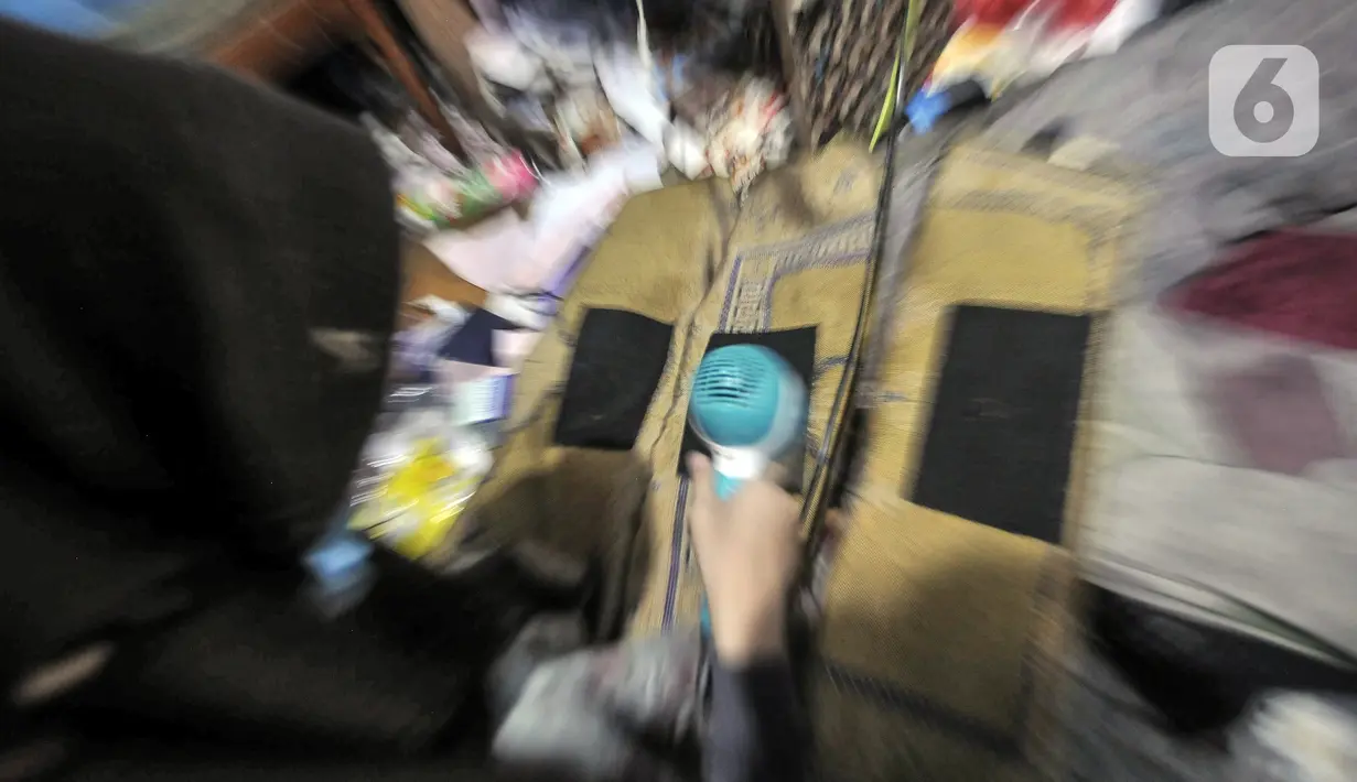 Fitri (40) menyelesaikan jasa sablon sajadah di Amang Sablon, Kebon Melati, Jakarta Pusat, Kamis (7/4/2022). Amang Sablon kini mampu menyelesaikan produksi sablon sajadah sebanyak 17-20 kodi per hari. (merdeka.com/Iqbal S. Nugroho)