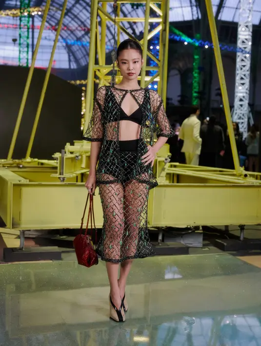 Jennie BLACKPINK tampil edgy dengan bra dan high waist shot pants hitam. Dibalut dengan setelan outer dan rok midi jaring-jaring [Chanel]