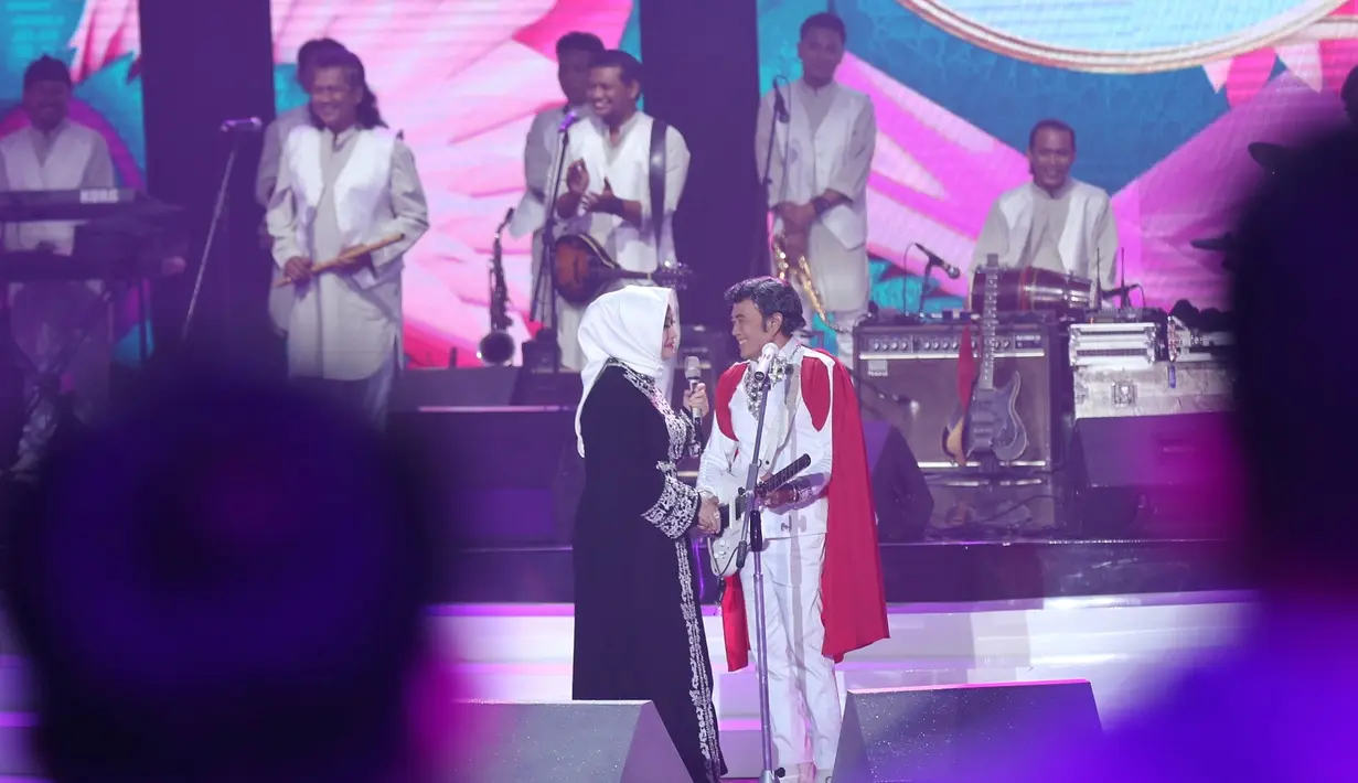"Ricca kok bisa sampai disini gimana?," tanya H. Rhoma pada istrinya di atas panggung. "Kebetulan saya diundang oleh Indosiar untuk acara Puteri Muslimah," ujarnya. (Nurwahyunan/Bintang.com)
