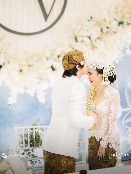 Prosesi akad nikah Kevin Aprilio dan Vicy Melanie berlangsung khidmat. Hanya dihadiri kurang dari 100 orang, suasananya pun kental dengan adat Sunda. Kevin dan Vicy mengenakan busana berwarna putih. (Instagram/thebridestory)