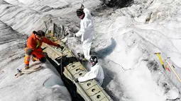 Anggota tentara Swiss memeriksa bagian pesawat tempur Perang Dunia II milik AS saat ditemukan di Gauli Glacier, di Bernese Alps, Swiss (17/9). Pesawat Perang Dunia II C-53 Skytrooper Dakota tersebut jatuh tahun 1946. (Peter Klaunzer/Keystone via AP)
