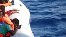 Seorang imigran termenung setelah diselamatkan di laut Mediterrania, (20/10). Penjaga pantai Italia mengatakan ribuan imigran berhasil diselamatkan di lepas pantai Libya. (Yara Nardi/Italian Red Cross press office/Handout via REUTERS)