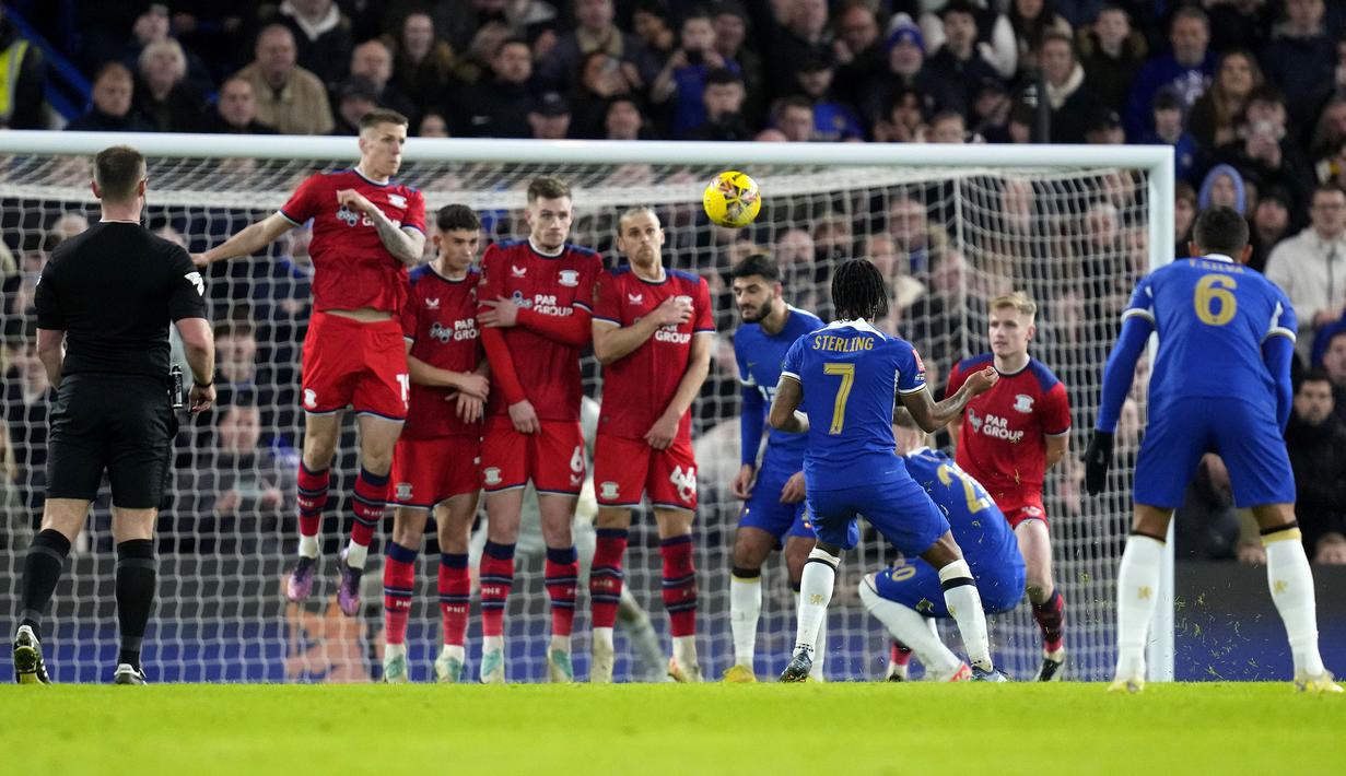 Pemain Chelsea, Raheem Sterling mencetak gol ke gawang Preston melalui tendangan bebas saat laga putaran ketiga Piala FA 2023/2024 di Stamford Bridge, London, Minggu (07/01/2024) WIB. (AP Photo/Kirsty Wigglesworth)
